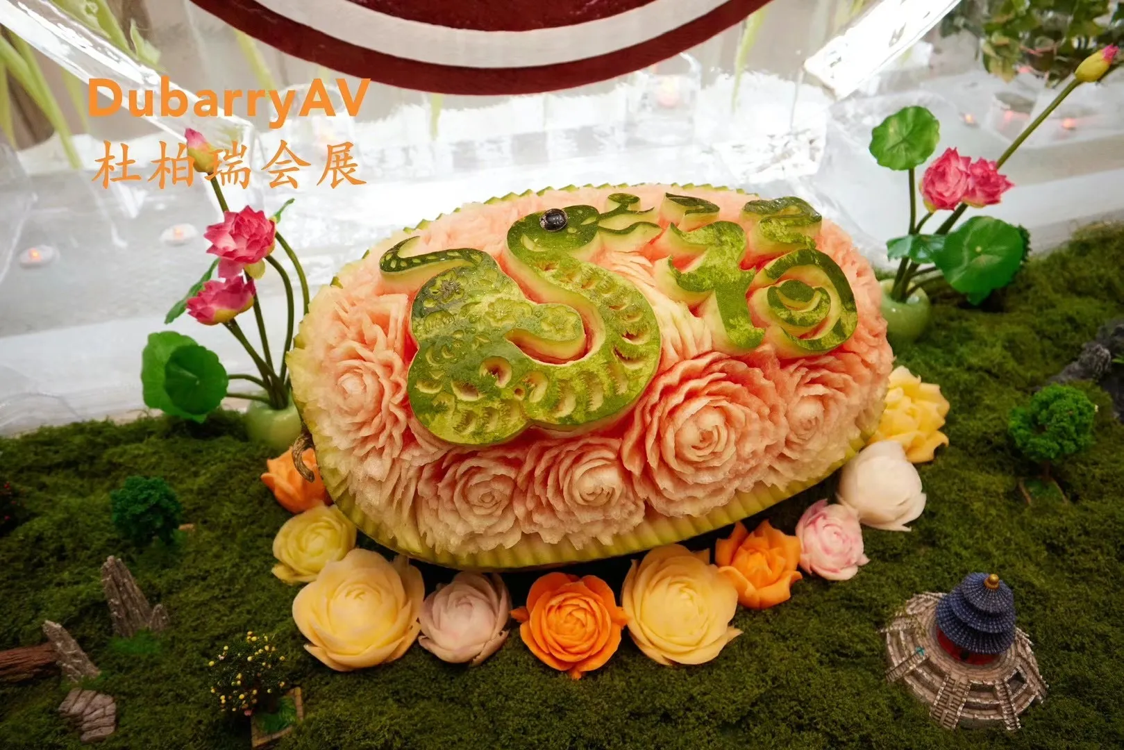 A carved melon showing a snake for the Year of the Snake, set among sugar flowers