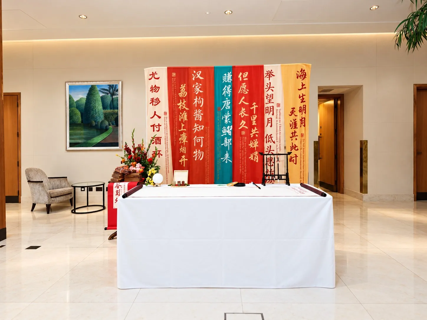 A calligraphy display of red and gold scrolls behind a white table