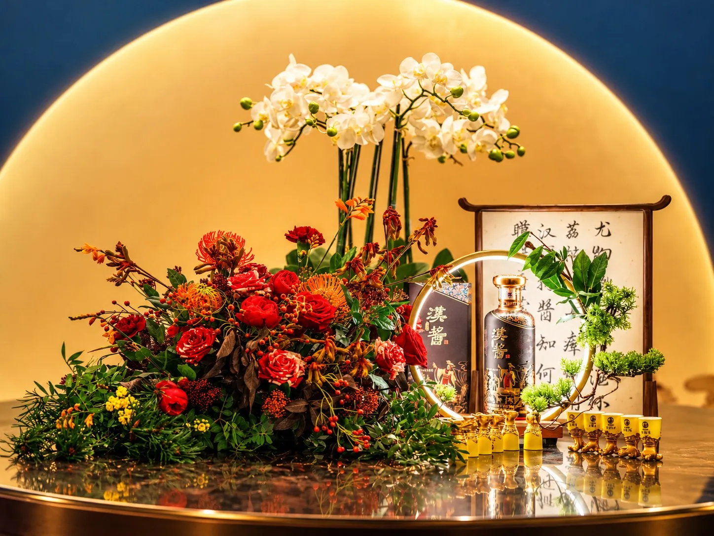 Floral styling of orchids and red blooms around a bottle of Hanjiang