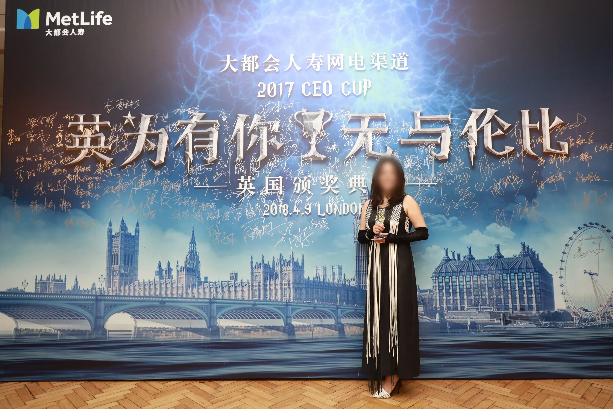 A host presenting on stage in front of the themed event screen