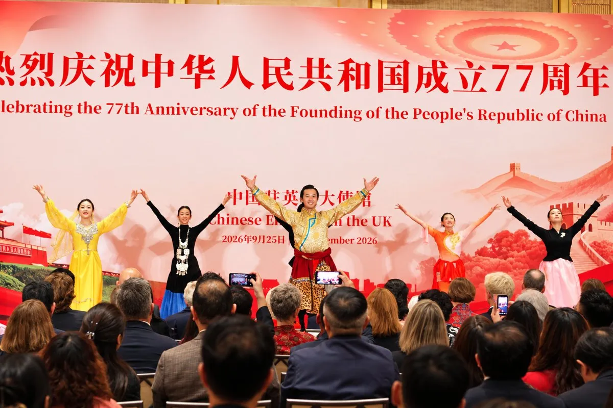 Dancers in traditional costume performing on stage before the celebration backdrop