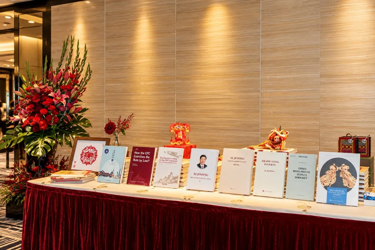 Books and cultural materials arranged beside a floral display